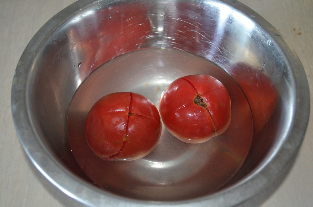 Надрезать томаты и кинуть в кипяток