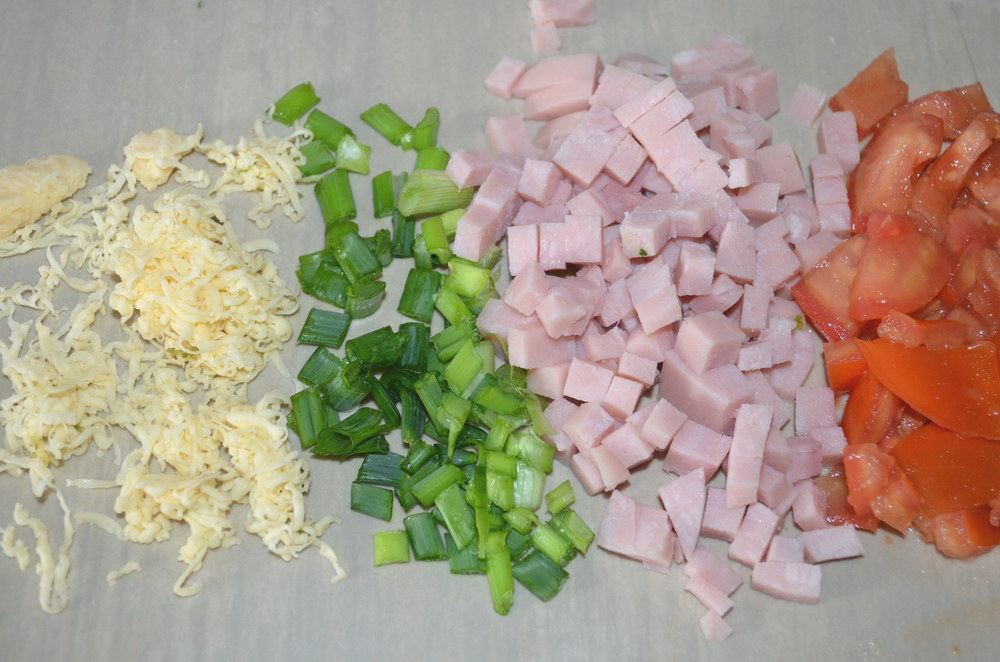 Мелко нарезать колбасу, лук, помидоры и натереть сыр